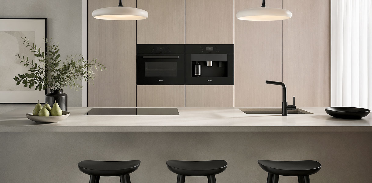 Japandi keuken met inbouwapparatuur zoals oven, koffiemachine en inductiekookplaat in strak greeploos design
