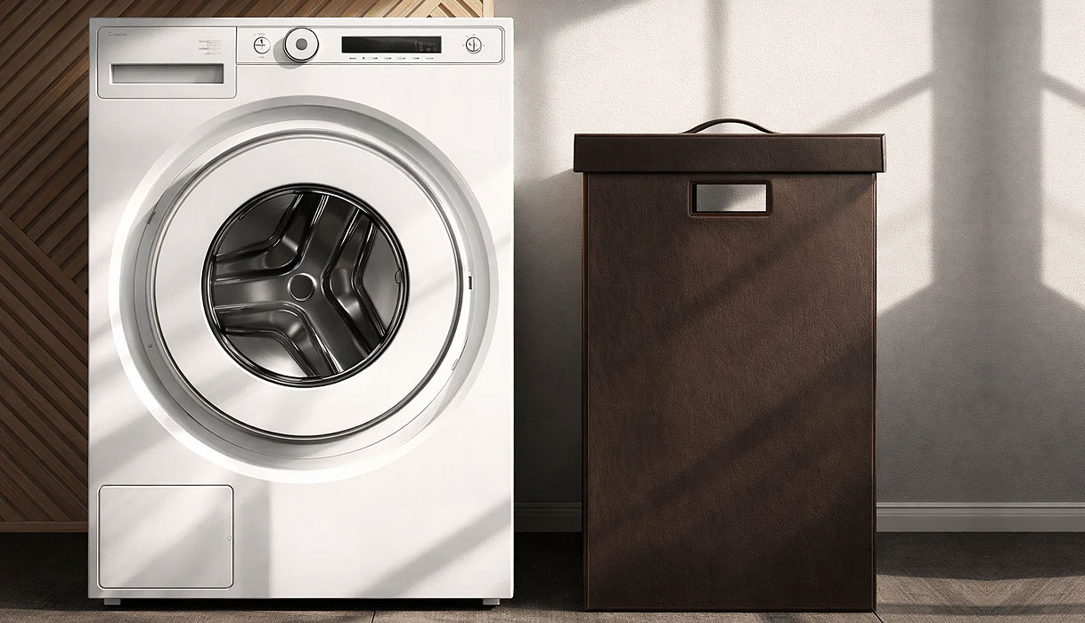 ASKO Classic voorlader wasmachine naast donkere wasmand in moderne wasruimte