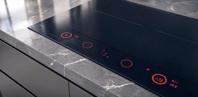 ATAG inductie kookplaat van bovenaf met drie bedieningsniveaus van slider tot touchscreen zichtbaar