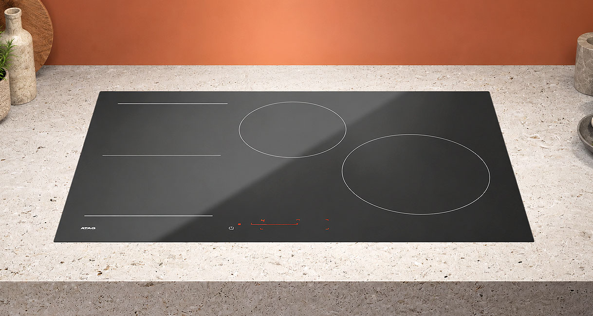 ATAG inductiekookplaat met ronde zones en flexzone in een licht stenen werkblad