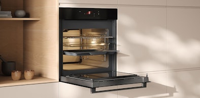 ATAG 6-serie inbouw magnetron in Black Glass met open deur in lichte houten keuken