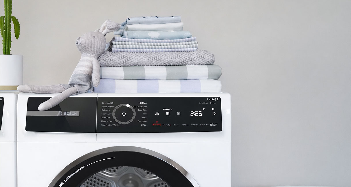 Bosch Serie 8 droger bedieningspaneel met AutoDry technologie naast stapel droge handdoeken