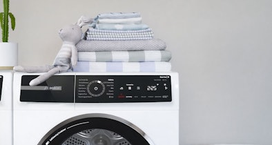 Bosch Serie 8 droger bedieningspaneel met AutoDry technologie naast stapel droge handdoeken