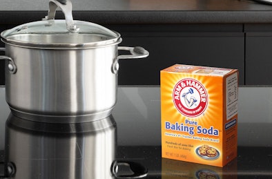 Baking soda op inductie kookplaat naast pan op kookzone