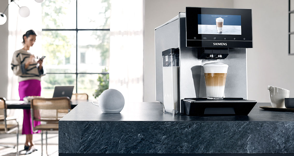 Vrouw die een Siemens volautomatische koffiemachine bedient via de app op haar telefoon