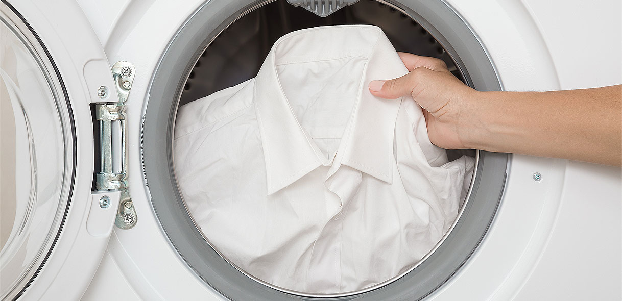 Wit overhemd wordt in wasmachine gedaan