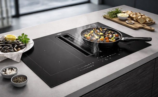 Beko inductiekookplaat met geïntegreerde afzuiging in kookeiland met pan mosselen waarvan de stoom direct wordt afgezogen.