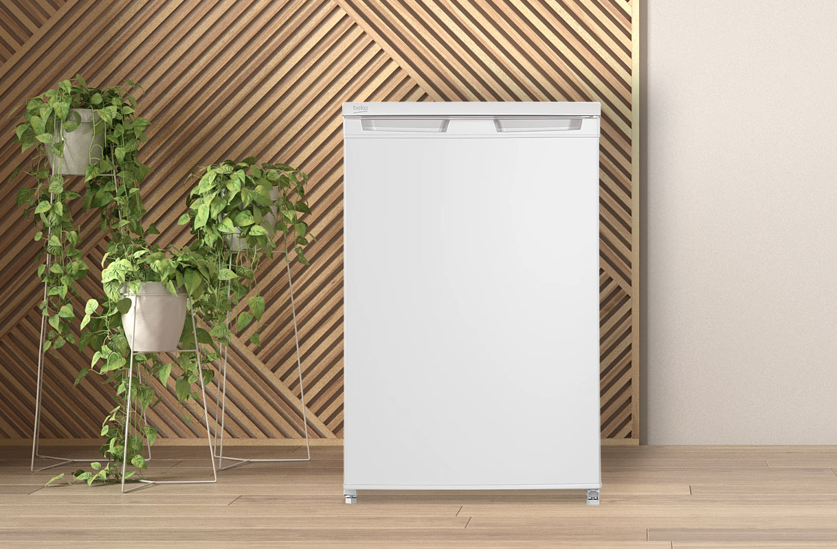 Witte Beko tafelmodel koelkast in moderne keuken met houten wand en groene kamerplanten