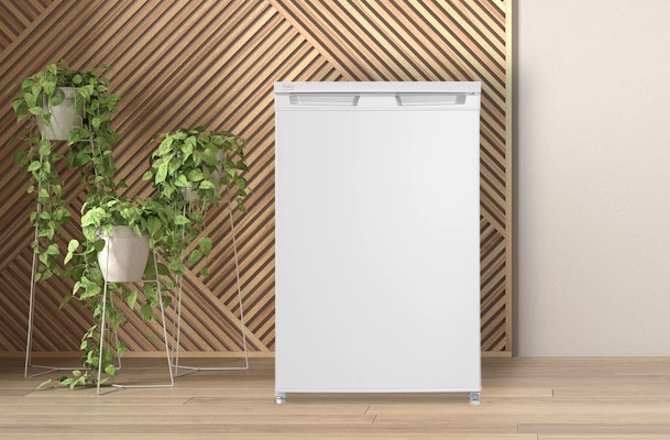 Witte Beko tafelmodel koelkast in moderne keuken met houten wand en groene kamerplanten