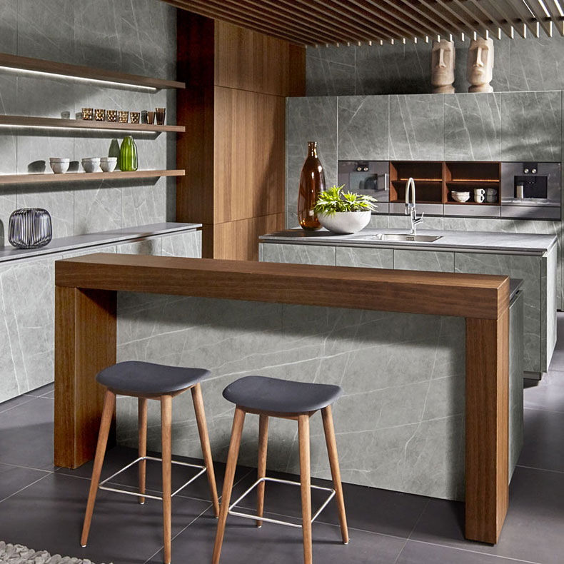 Betonlook keuken met houten bar en elementen.