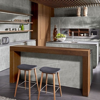 Betonlook keuken met houten bar en elementen.