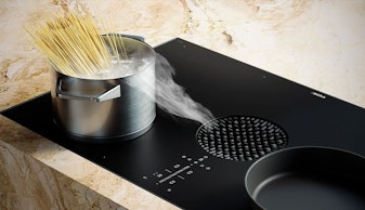 Bora kookveldafzuiging in een inductiekookplaat met dampende pan zonder afzuigkap