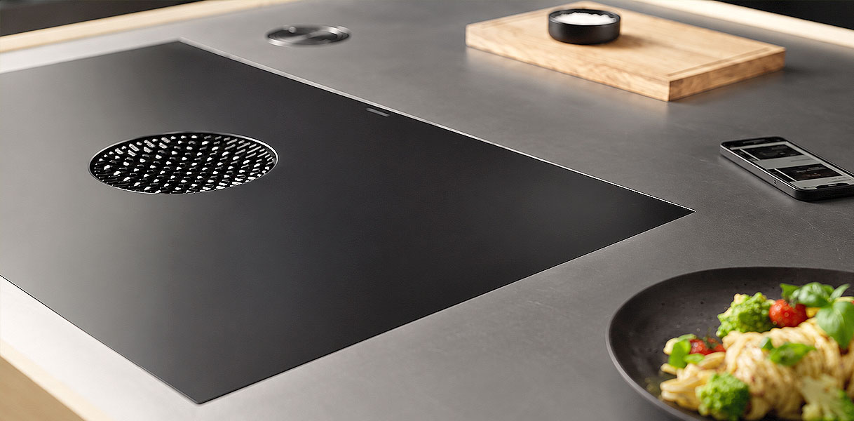 BORA Pure kookplaat met afzuigopening en steelpan op kookzone in close-up op werkblad
