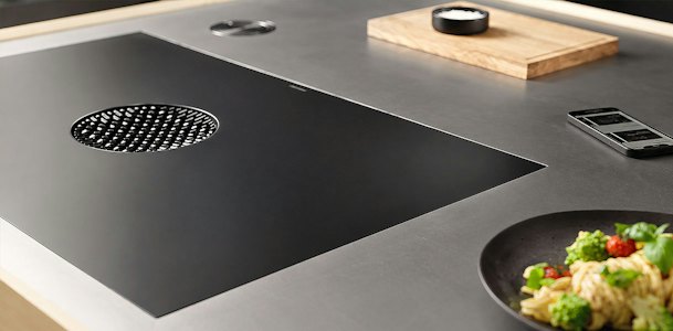 BORA Pure kookplaat met afzuigopening en steelpan op kookzone in close-up op werkblad