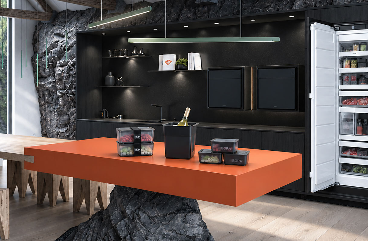 BORA Freeze inbouwvriezer met geopende deur en accessoires op een oranje kookeiland, waaronder voorraaddozen met diepvriesproducten, portievormen en een wijnkoeler.