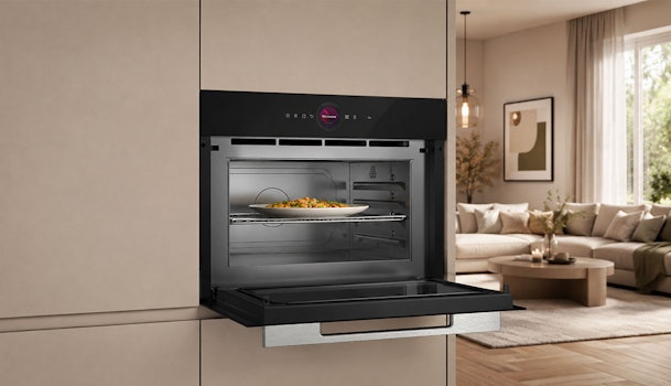 Bosch inbouw magnetron in zandkleurige keuken met bord eten op het ovenrek