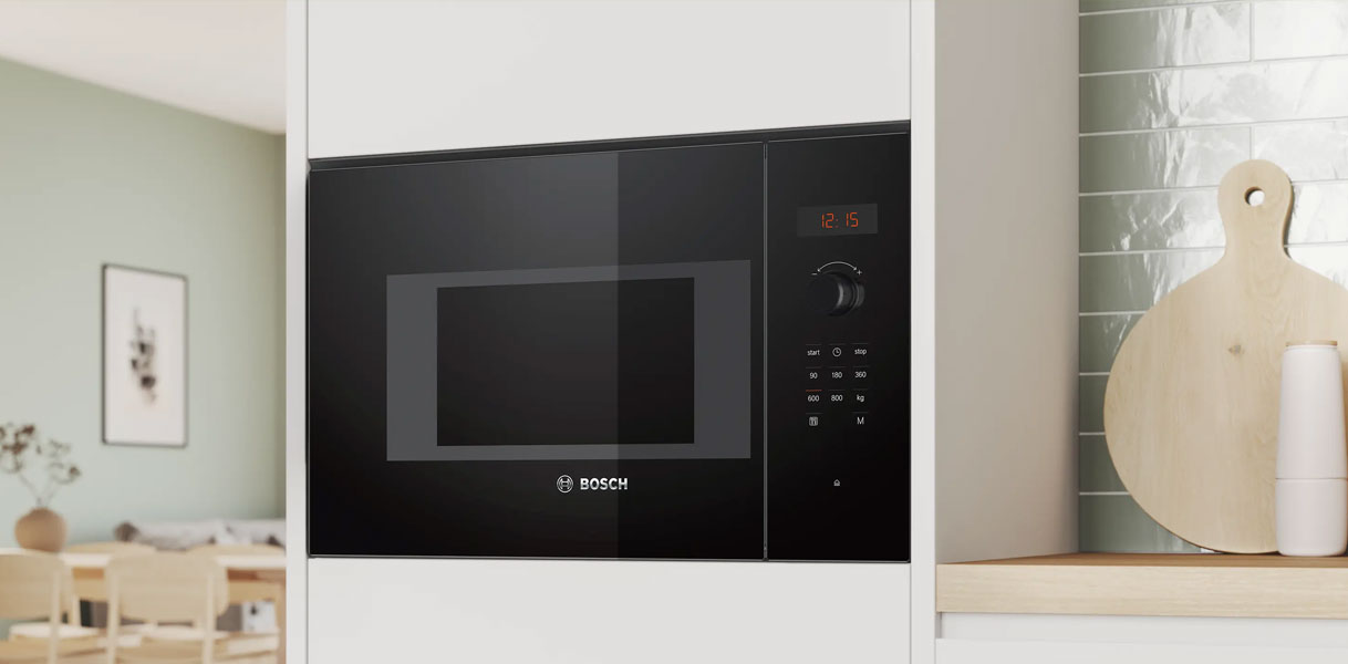Bosch Serie 2 en 4 inbouw magnetron in zwart ingebouwd in lichte Scandinavische keuken met snijplank