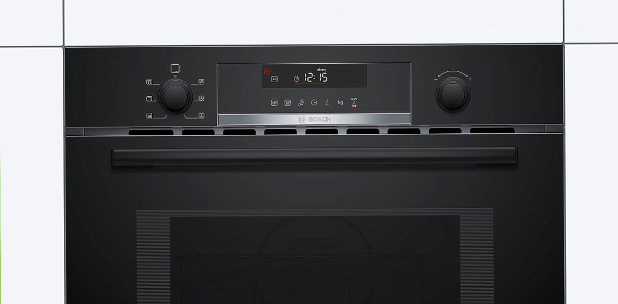 Bosch zwarte inbouw magnetron met digitaal display en draaiknoppen in donkere keukennis