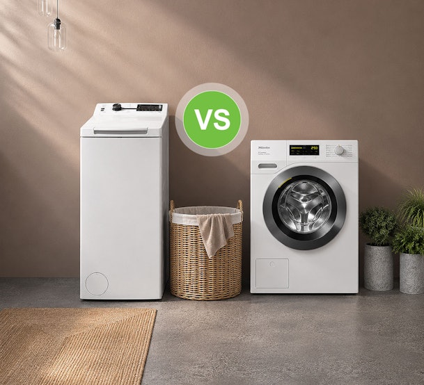 Smalle bovenlader wasmachine naast bredere voorlader met wasmand ertussen ter vergelijking
