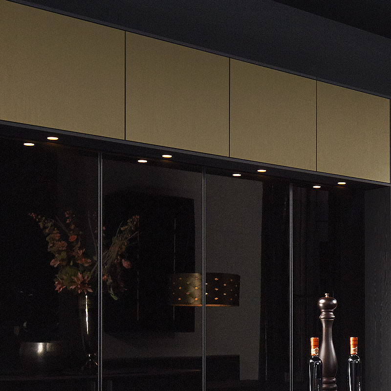 Bovenlijst in Brown Steel met zwarte glaswand en inbouwspots.