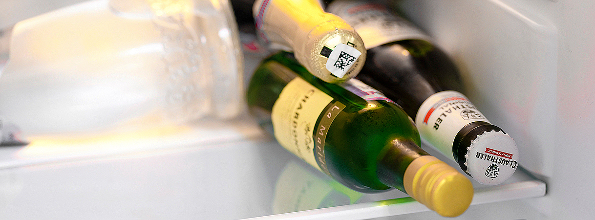 Flessen en potjes liggen dicht tegen elkaar aan in een koelkastvak.