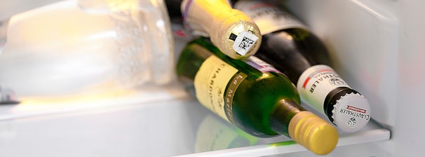 Flessen en potjes liggen dicht tegen elkaar aan in een koelkastvak.