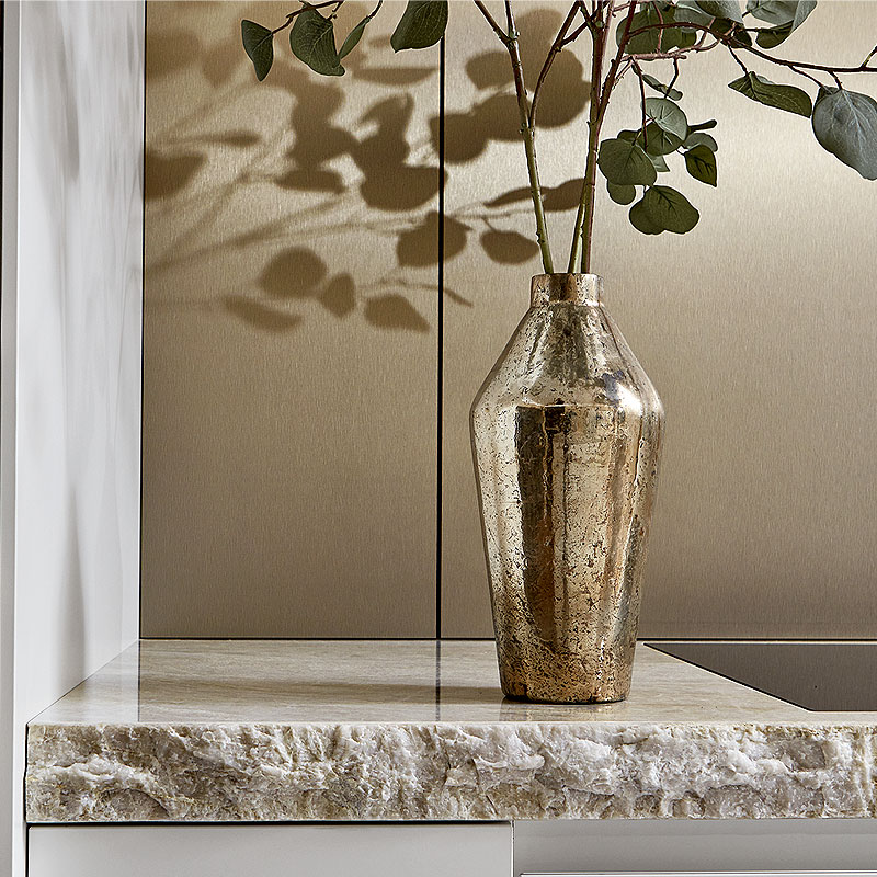 Natuurstenen blad met bronskleurige achterwand en accessoire.