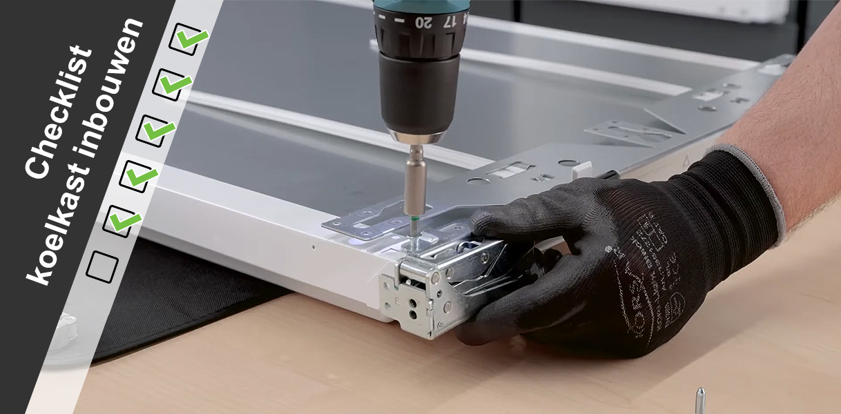 Monteur bevestigt koelkastscharnier tijdens het controleren van de inbouwchecklist