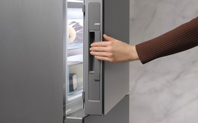 Hand opent Miele vriezerdeur met Click2open systeem voor moeiteloze bediening