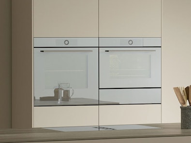V-ZUG combi-oven bakoven met stoom functionaliteit ingebouwd in moderne keuken met glaskan op aanrecht