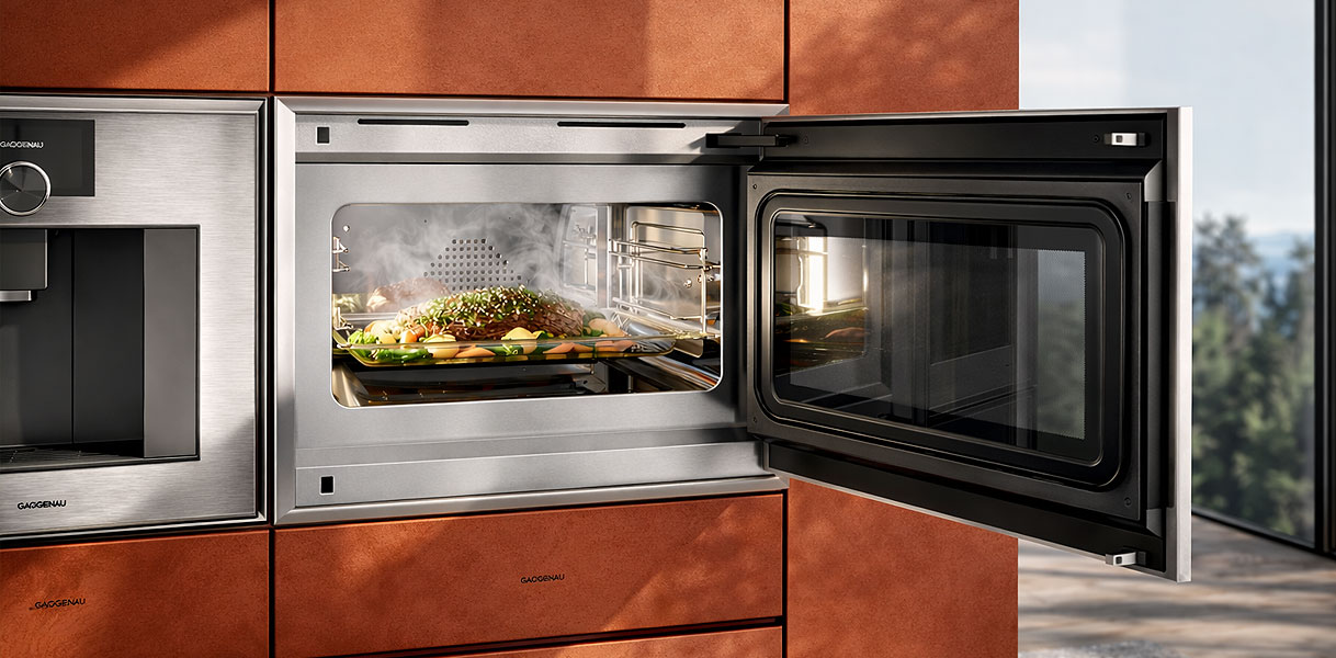 Gaggenau combimagnetron met open deur en dampende maaltijd in luxe koper keuken voor veelzijdig koken