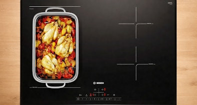 Bosch inductiekookplaat met CombiZone en een braadslede met groenten op het samengevoegde kookoppervlak