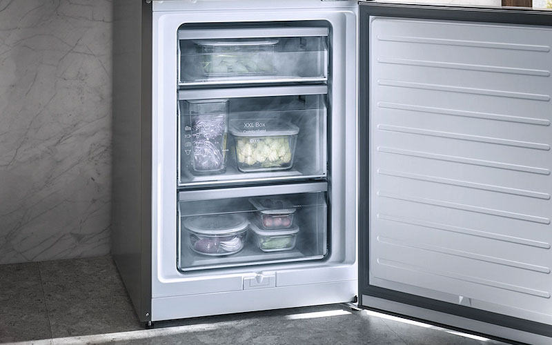 Openstaande Miele vriezer met ComfortFrost technologie, gevuld met diepvriesproducten in transparante lades, voor minder ijsvorming en minder vaak ontdooien.