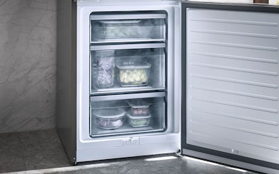 Openstaande Miele vriezer met ComfortFrost technologie, gevuld met diepvriesproducten in transparante lades, voor minder ijsvorming en minder vaak ontdooien.