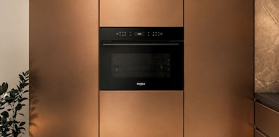 Compacte combi-oven van 45 cm hoog ingebouwd in koperkleurige keukenwand