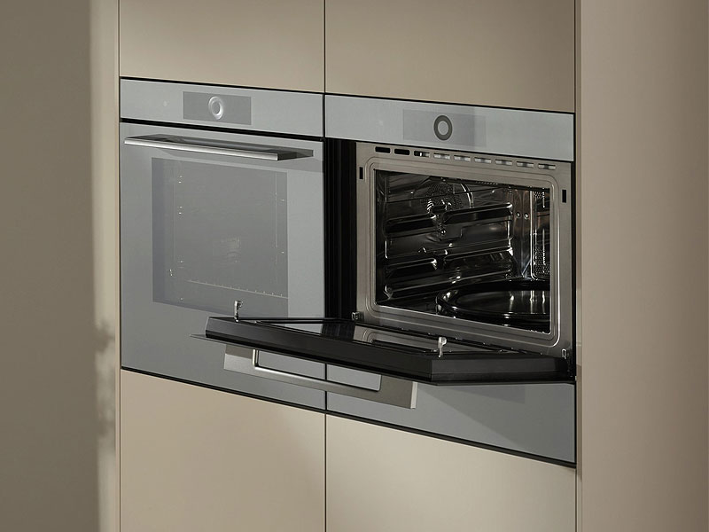 V-ZUG compacte oven geopend met meerdere roosters en bakplaten in ruimtebesparend 45cm design