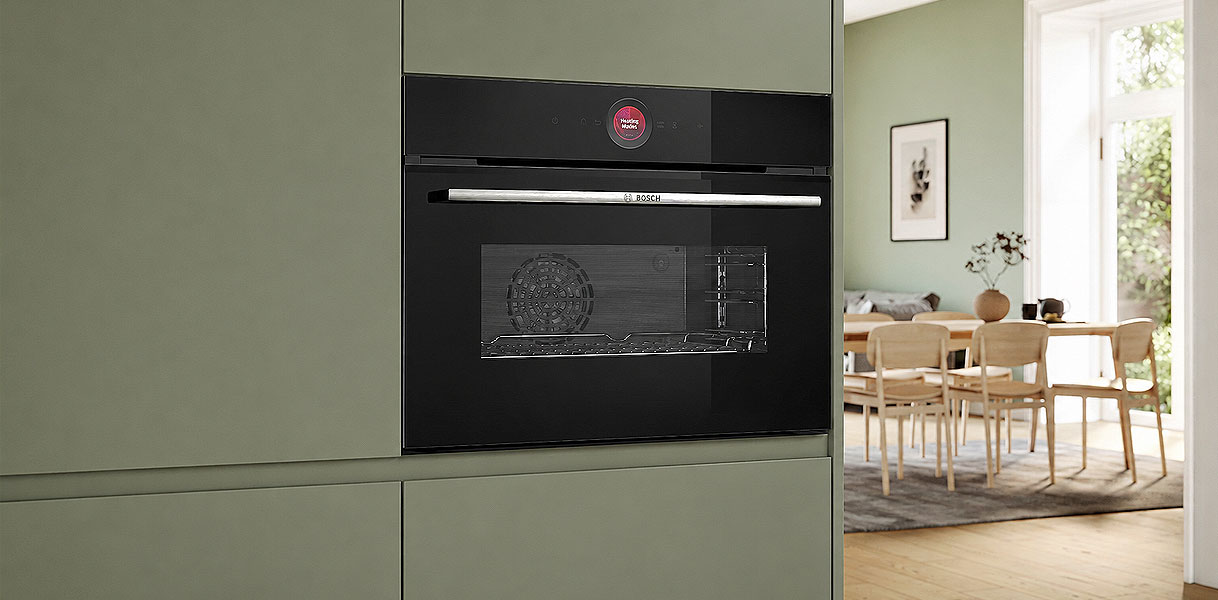 Compacte solo oven van 45 cm hoog ingebouwd in een kastenwand naast de eethoek