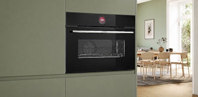 Compacte solo oven van 45 cm hoog ingebouwd in een kastenwand naast de eethoek