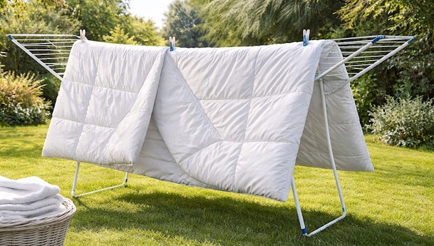 Dekbed drogen zonder droger op wasrek buiten in de tuin voor natuurlijk luchtdrogen