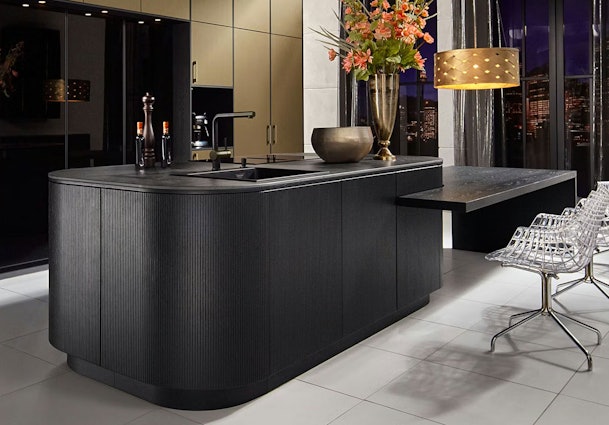 Design kookeiland met afgeronde vormen, zwart front en luxe werkblad in moderne keuken
