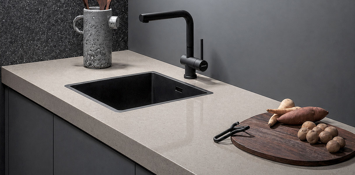 Designkeuken met fenix keukenblad, zwarte spoelbak en houten snijplank met groenten