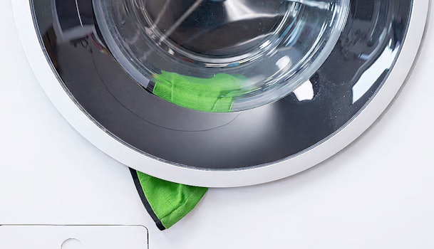 Kleding zit klem tussen deur en manchet van wasmachine waardoor deur niet opent