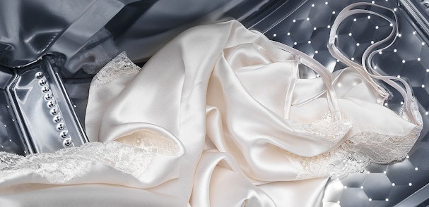 Delicate zijden kleding met kant in wasmachine trommel
