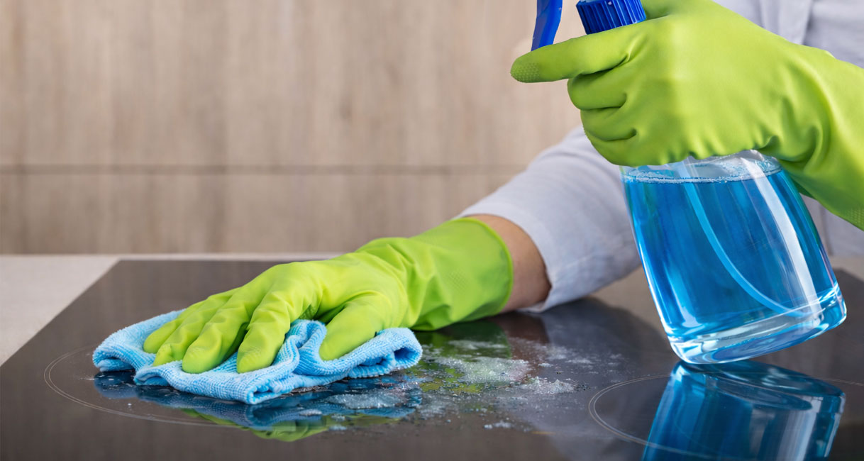 Doffe vlekken op een inductiekookplaat verwijderen met microvezeldoek en glasreiniger