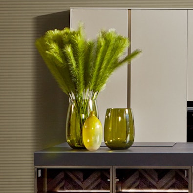 Donker werkblad met subtiele glans en hoog contrast tegenover lichte fronten.