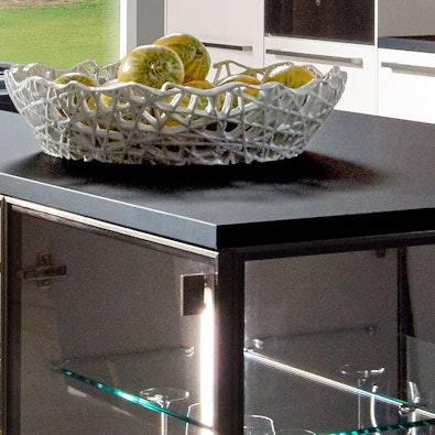 Verlichte vitrineeiland met glazen planken en LED.