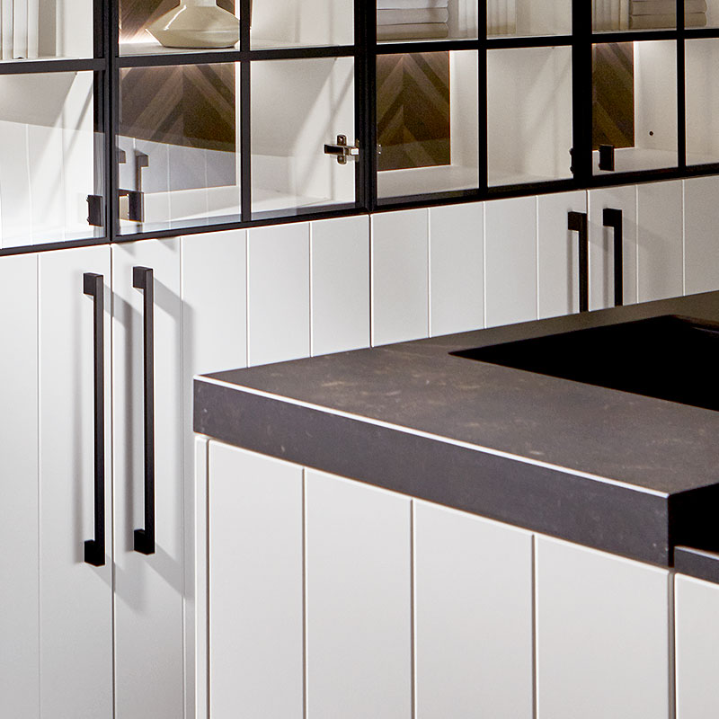 Donker werkblad met strakke rand boven arctiswitte fronten.