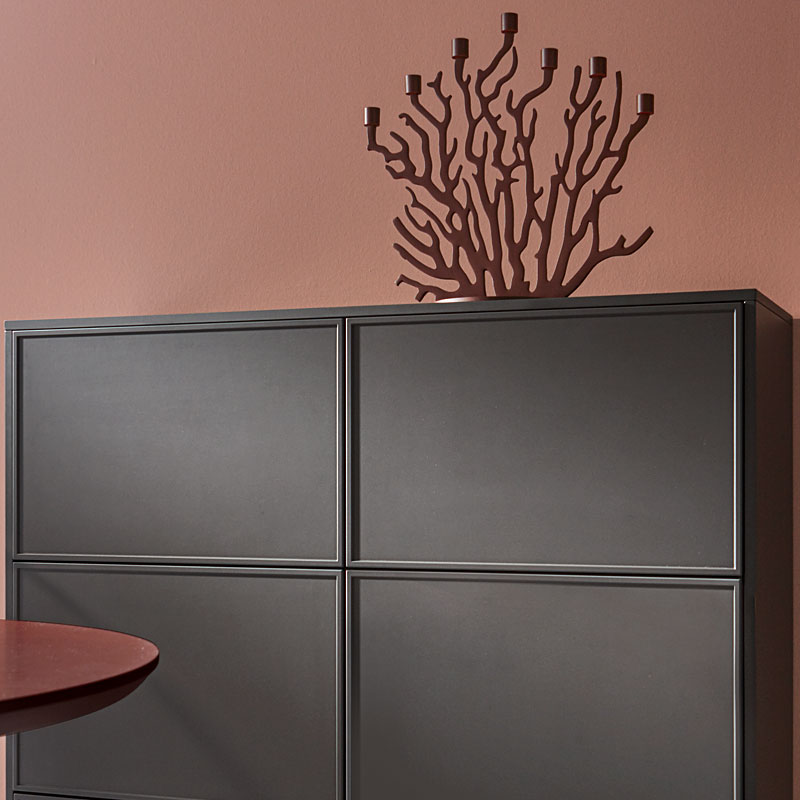 Donkere opbergkast tegen terracotta muur.