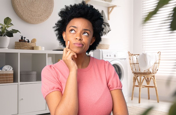 Vrouw twijfelt welke wasdroger het beste bij haar past in moderne wasruimte met wasmachine en droger