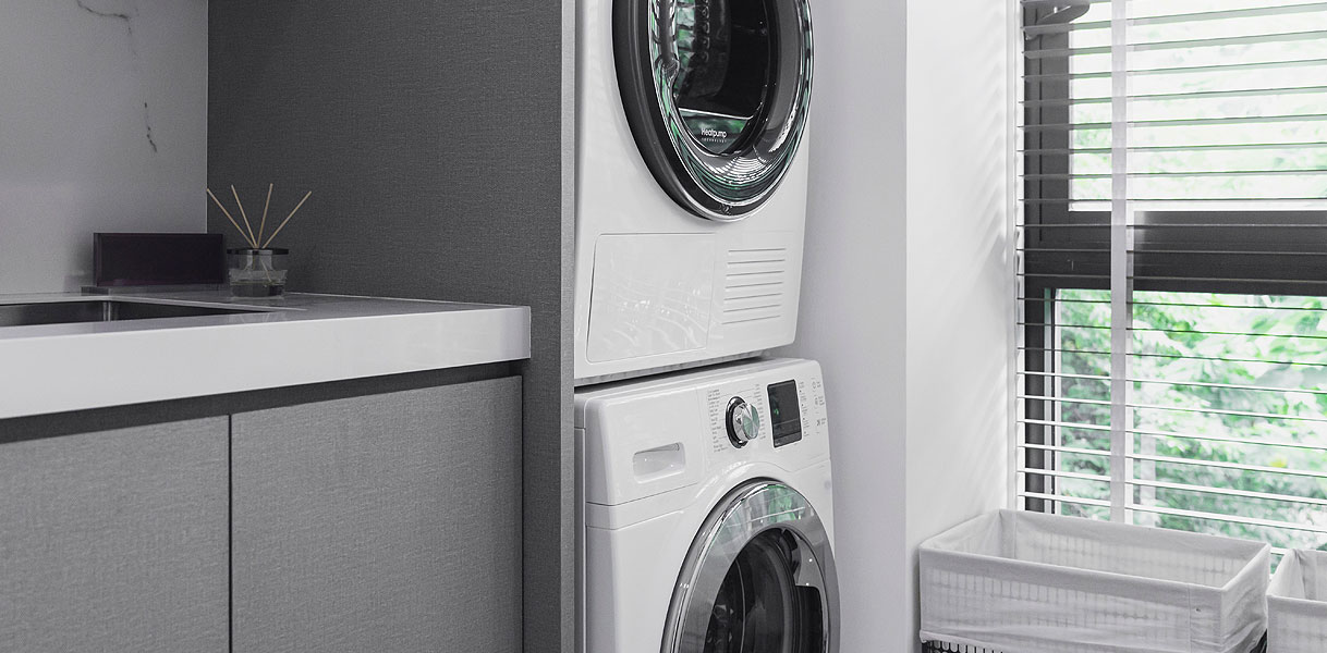 Droger gestapeld op wasmachine in moderne wasruimte